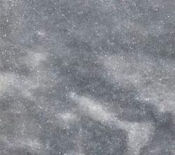 Close-up view of a gray marble tile surface with subtle white veins and specks, showcasing a natural, slightly cloudy texture.