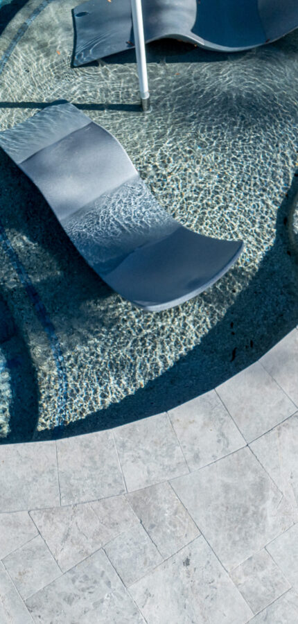 Tundra Grey pool coping stone on luxury swimming pool edge, natural stone pool border design